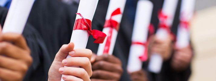 A line of graduates holding scrolls